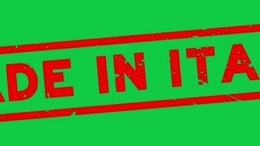 Grunge kırmızısı İtalya 'da üretilmiş. Kauçuk mühür damgası yeşil arka planda yakınlaştırılmış.
