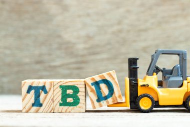 TBD (tanımlanacak, tartışılacak, kararlaştırılacak, kararlaştırılacak, silinecek veya beyan edilecek) sözcüğünün kısaltılması için oyuncak forklift harfi engeli d) tahta arkaplanda