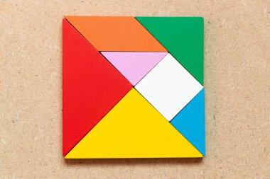 Ahşap arkaplanda kare veya dikdörtgen şeklinde renk tangramı yapbozu