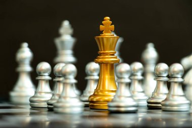 Satranç oyununda altın kral, siyah arka planda diğer gümüş takımıyla birlikte devam etti (Şirket stratejisi, iş krizi veya karar kavramı)