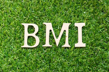 Alfabe harfi BMI (vücut kütle indeksinin kısaltması) yeşil çimen arka planında