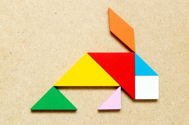 Ahşap zemin üzerinde balık şeklinde renkli tangram yapbozu