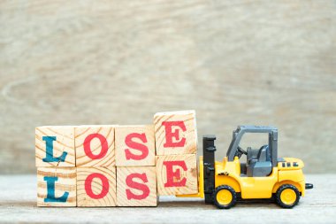 Oyuncak forklift harf bloğunu tut. Kelimeyi tamamlamak için tahta arkaplanda kaybet