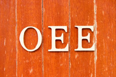 Kelime olarak alfabe harfi OEE (genel ekipman etkinliğinin kısaltılması) eski kırmızı tahta arka plan üzerinde