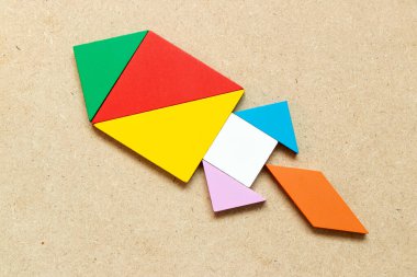 Ahşap zemin üzerinde roket ya da füze şeklinde renk tangramı yapbozu