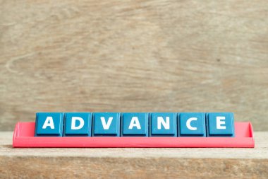 Ahşap arkaplanda kırmızı renk rafında kelime ilerlemesi içeren döşeme alfabesi harfi