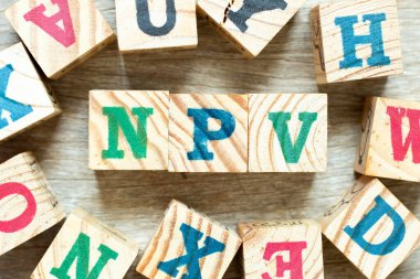 Kelime NPV ile alfabe harf bloğu (bugünkü net değerin kısaltılmışı) ve ahşap arkaplan üzerine başka bir harf bloğu