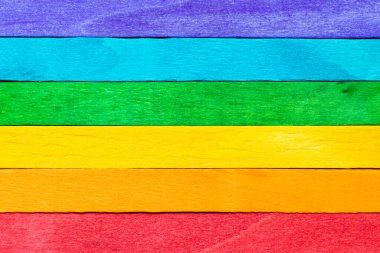 Kopya alanı ile desenli arkaplan, çerçeve ve dekorasyon olarak çok renkli tahta kullanımı (Gökkuşağı veya LGBT kavramı)