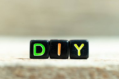 Ahşap zemin üzerinde DIY (kendin yap kısaltması) sözcüğüyle siyah renk bloğu