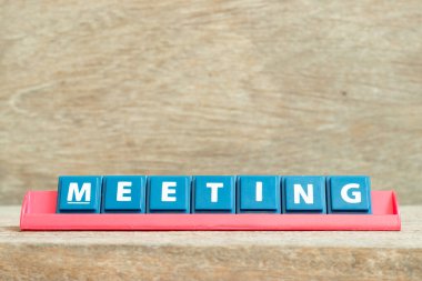 Ahşap arkaplanda kırmızı renk rafında kelime toplantısıyla birlikte alfabe harfini döşe