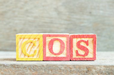 Ahşap zemin üzerinde kelime COS (Satışların Maliyetinin kısaltılması, Hizmet Sınıfı, Kosinüs) renk alfabesi bloğu