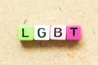 Ahşap arka planda kelime LGBT (lezbiyen, gey, biseksüel ve transseksüel kısaltması) renk alfabesi harfi bloğu