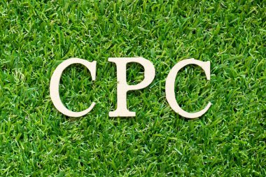 Yeşil çimen arka planında kelime CPC (tıklama başına maliyetin kısaltılmışı) ile alfabe harfi