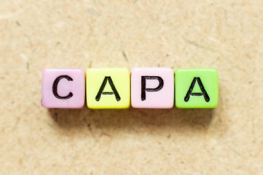 Kelime CAPA ile renk alfabesi harfi bloğu (tahta arkaplanda düzeltici eylem ve önleyici eylemin kısaltılması)