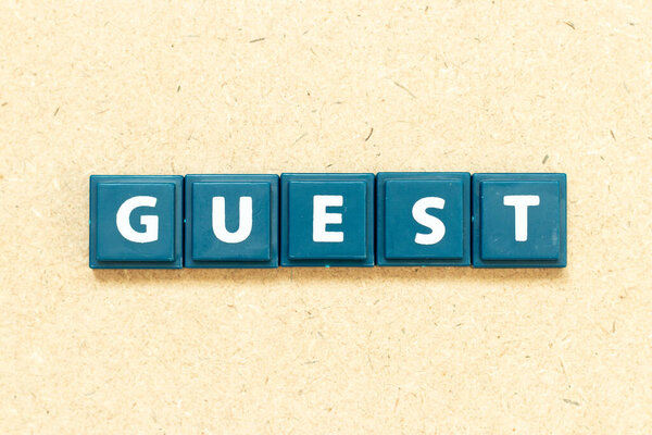 Tile alphabet letter in word guest on wood background