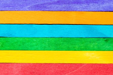 Kopya alanı ile desenli arkaplan, çerçeve ve dekorasyon olarak çok renkli tahta kullanımı (Gökkuşağı veya LGBT kavramı)