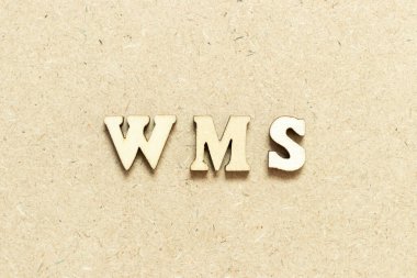 Tahta zemin üzerinde WMS (depo yönetim sisteminin kısaltması) kelimesindeki alfabe harfi