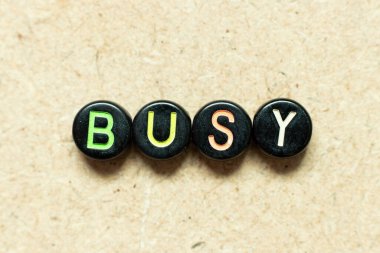 Siyah renk yuvarlak alfabe harf bloğu tahta arka planda meşgul