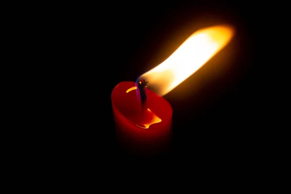 黑色背景上有黄色火焰的红色蜡烛 — 图库照片