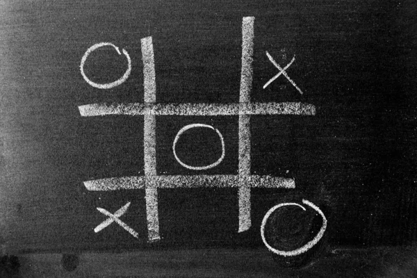 White color chalk hand drawing as Tic Tac Toe with the winner and loser shape on blackboard or chalkboard background