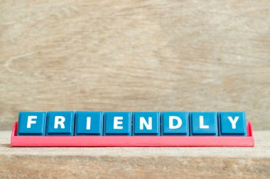 Ahşap zemin üzerinde kırmızı renkli raflarda kelime dostu harf döşeme alfabesi