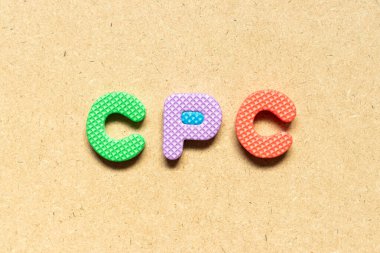 Kelime CPC ile köpük alfabesi harfi (tıklama başına maliyetin kısaltması) tahta arkaplan üzerinde