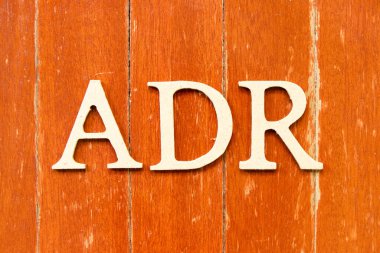 Eski kırmızı tahta arka plan üzerinde ADR (ters uyuşturucu reaksiyonunun kısaltması) kelimesindeki alfabe harfi