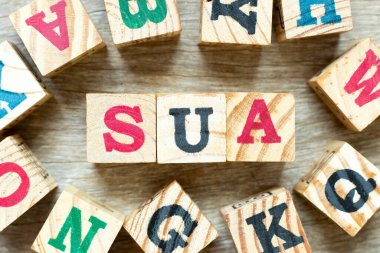 Alphabet letter block in word SUA (Abbreviation of Single use account) with another on wood background