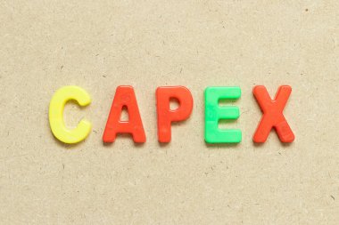 Ahşap zemin üzerinde CAPEX (Sermaye Harcamalarının kısaltması) sözcüğüyle renk alfabesi harfi