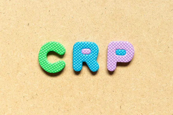 Foam alphabet letter in word CRP (abbreviation of C-Reactive Protein Test) on wood background