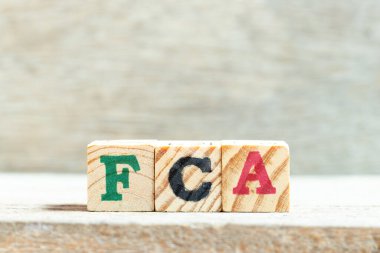 Tahta zemin üzerinde FCA (ücretsiz taşıyıcının kısaltması) kelimesindeki alfabe harf bloğu