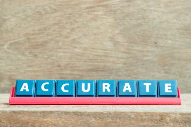 Ahşap arkaplanda kırmızı renk rafında doğru sözcüğe sahip döşeme alfabesi harfi