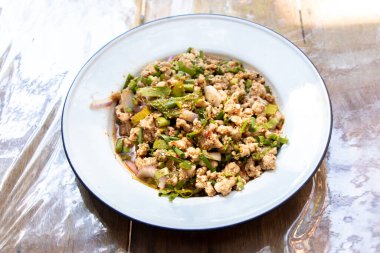 Tahta arka planda Tayland yemeği baharatlı kıymalı domuz salatası.