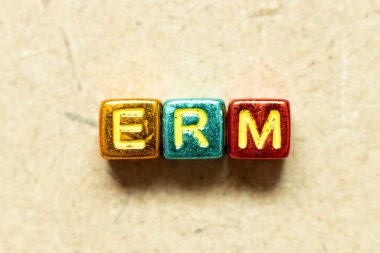 Metallic color alphabet letter block in word ERM (Abbreviation of Enterprise risk management) on wood background