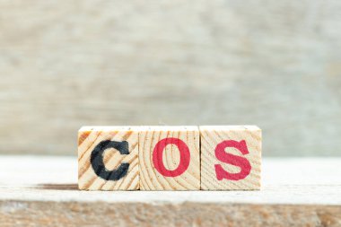 Tahta zemin üzerinde COS (Satışların Maliyetinin kısaltılması, Hizmet Sınıfı, Kosinüs) kelimesindeki alfabe harfi bloğu
