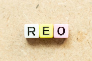 Kelime REO ile renk alfabesi harfi bloğu (ahşap arkaplan üzerindeki gayrimenkulün kısaltması)