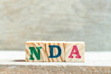 Alfabe harf bloğu kelime NDA (Ahşap arkaplan üzerinde Non ifşaat anlaşması kısaltması)