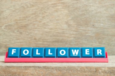 Tahta arkaplanda kırmızı renk rafında kelime takipçisinin bulunduğu tuğla alfabesi harfi