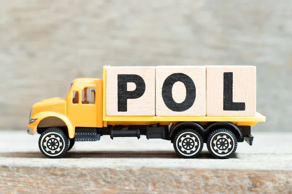 stock image Toy truck hold alphabet letter block in word POL (Abbreviation of Port of loading or price online) on wood background