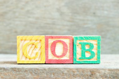 Ahşap zemin üzerinde kelime COB ile renk alfabesi harfi bloğu (iş kapatma kısaltması)