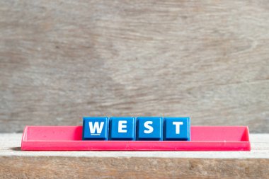 Kırmızı raftaki döşeme harfi ahşap arka plandaki sözcüğün batısında