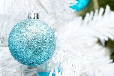 Noel ağacı arkaplanının beyaz dalında mavi renkli top (Noel ve Yeni Yıl Festivali için dekorasyon