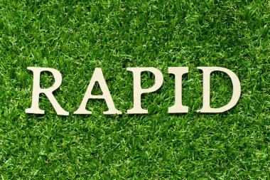 Yeşil çimen arka planında kelime hızlı ahşap harf