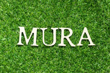 Yeşil çimen arka planında Mura harfiyle alfabe harfi