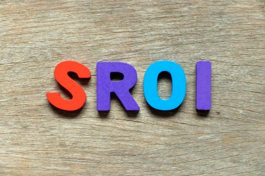 Kelime SROI ile renk alfabesi harfi (Yatırımda Sosyal Dönüş kısaltması) ahşap arkaplan üzerine