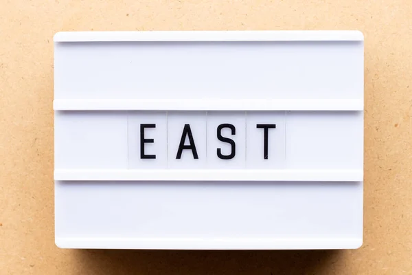 木製の背景に単語東とLightbox — ストック写真