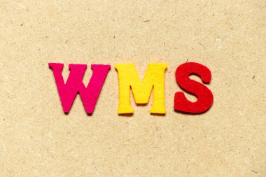 Kelime WMS ile renk bezi alfabesi harfi (depo yönetim sisteminin kısaltması) ahşap arkaplan üzerine