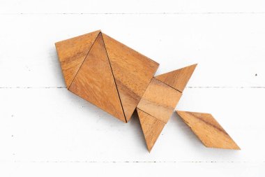 Beyaz ahşap zemin üzerinde roket ya da füze şeklinde ahşap tangram yapboz