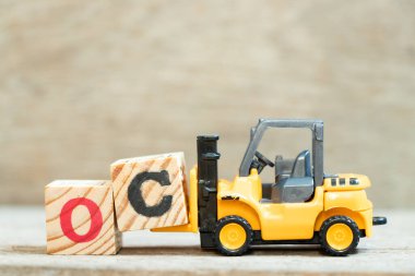 Oyun forklift harf bloğu C 'yi tahta arkaplan üzerindeki OC (fırsat maliyetinin kısaltılması veya özgün içerik, karakter) tamamlamak için tut