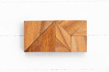 Beyaz ahşap zemin üzerinde kare ya da dikdörtgen şeklinde ahşap tangram yapbozu